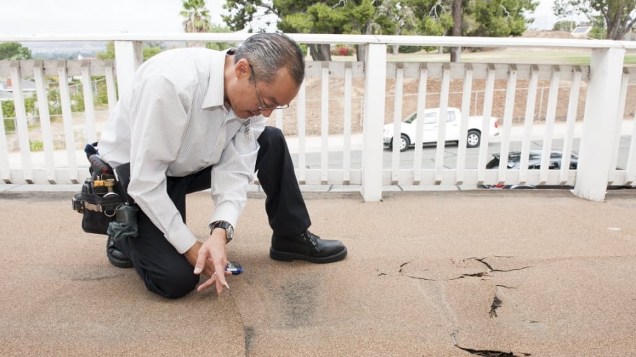 man inspecting a damaged deck