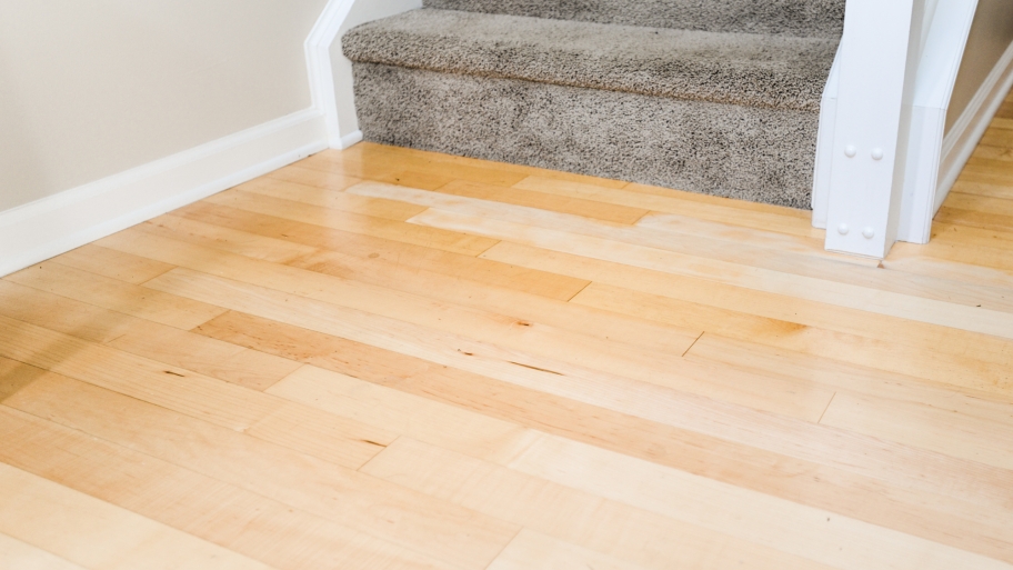 hardwood floor at bottom of carpeted stairs