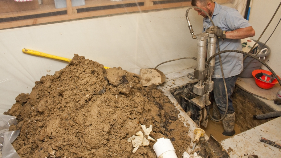 septic worker digging in basement