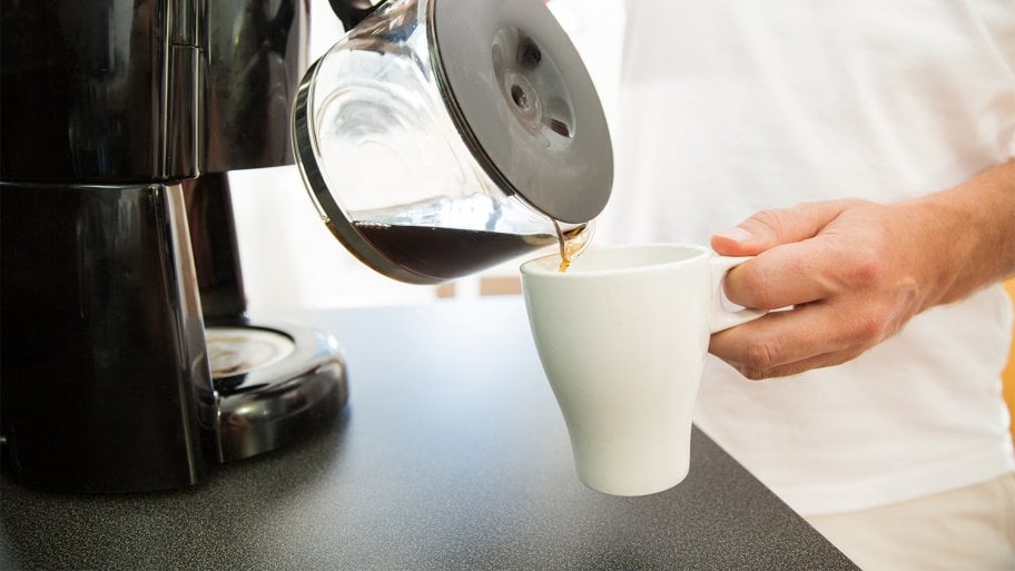 Man pouring coffee into mug