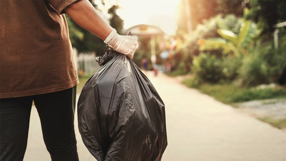 Man removing waste in trash back