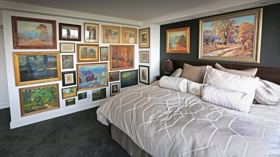 master bedroom with wall of artwork