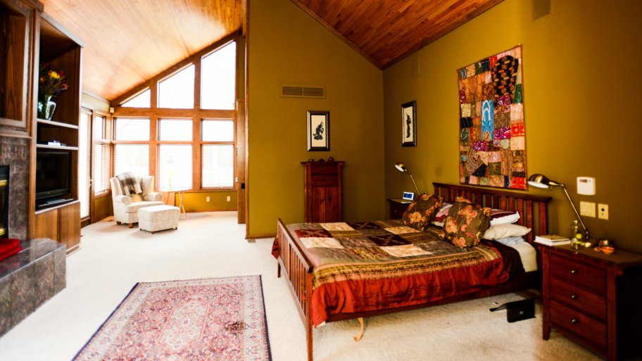 master bedroom with tall windows and fireplace