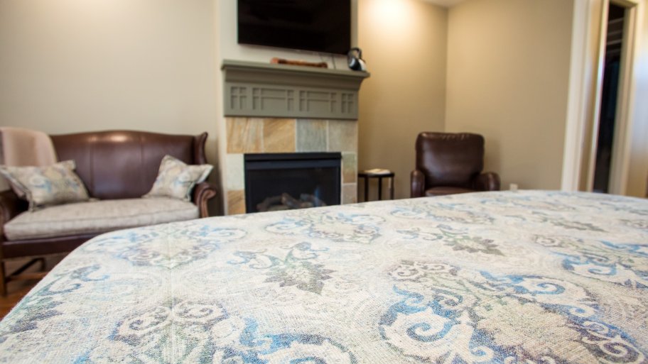 master bedroom with a fireplace, chair and loveseat
