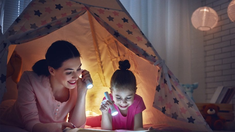Mom and daughter reading by flashlight