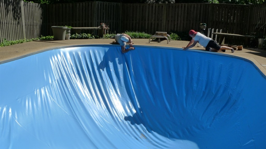 workmen replace a pool liner