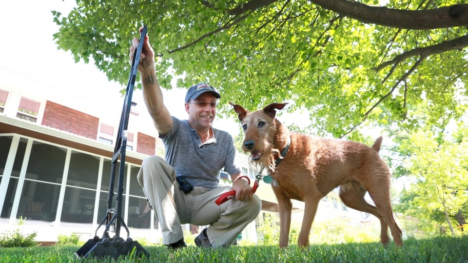 man with dog and pooper scooper
