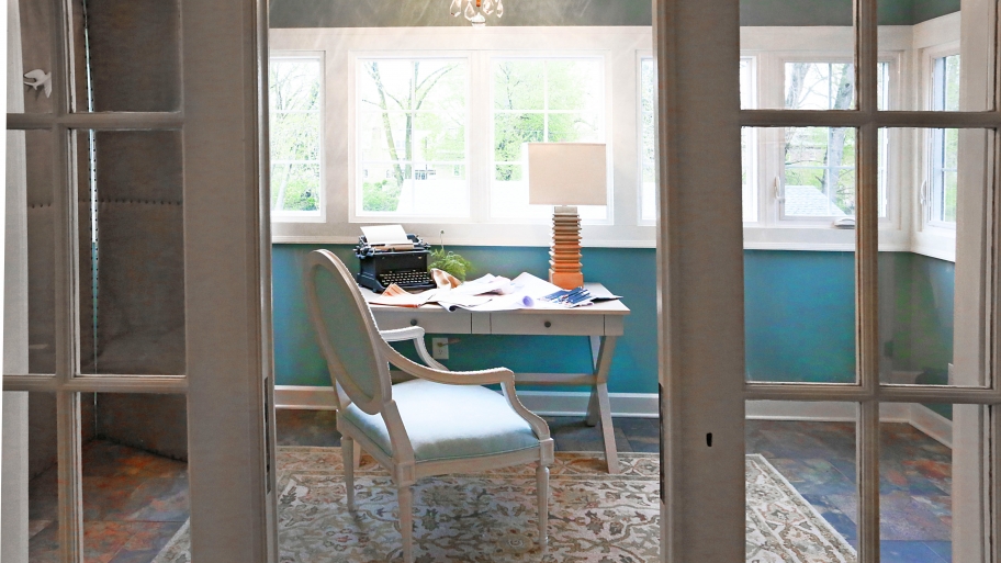 remodeled sun room with desk and chair in front of windows