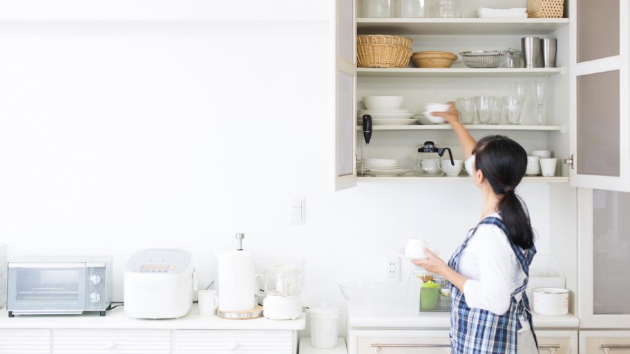 A woman organizing her kitchen (Photo by kazoka30 / iStock / Getty Images Plus via Getty Images)