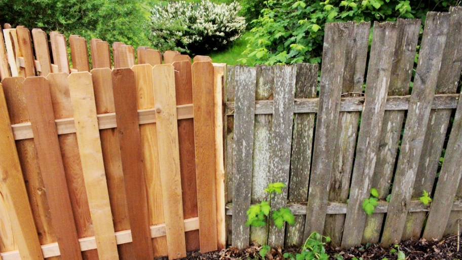 Gray old fence next to fresh new fence
