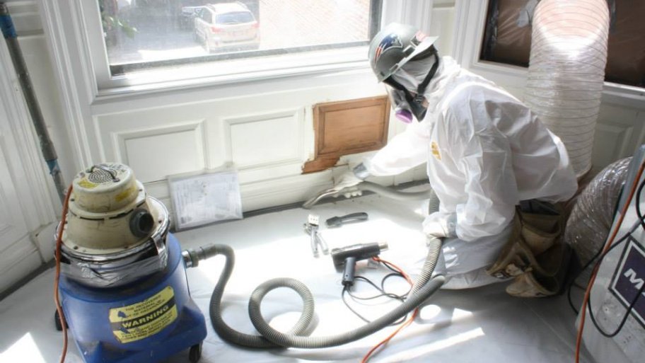contractor removing lead paint from window and wall