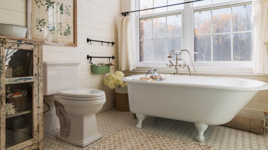a vintage style bathroom with bathtub, sink, and large windows