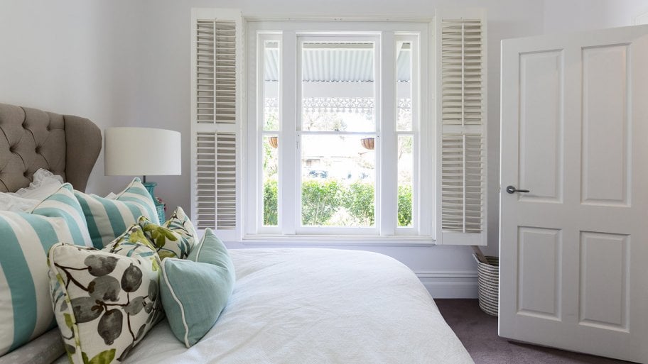 Bedroom with shutters at window