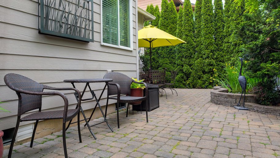 Backyard patio with chairs and table on brick pavers