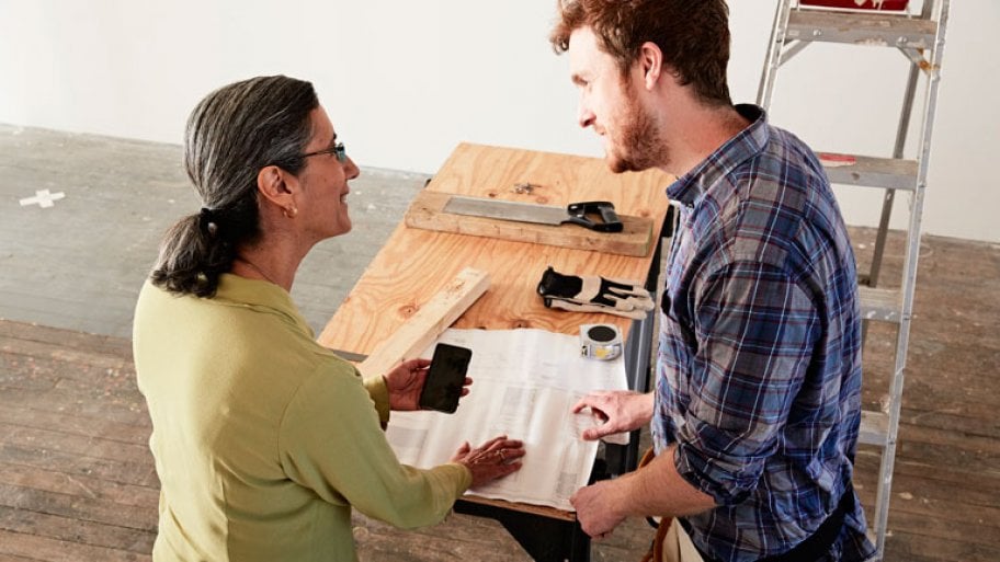 Carpenter showing blueprint to client