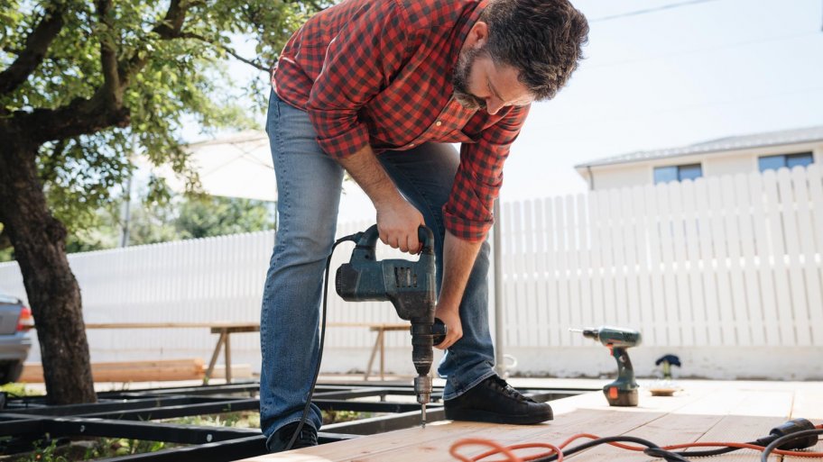 A carpenter installing a new wooden deck