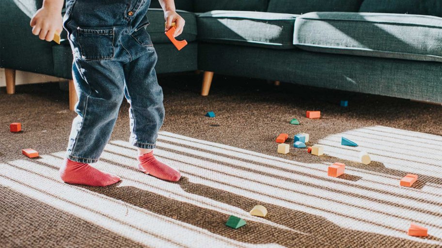 Child playing with toys on living room carpet