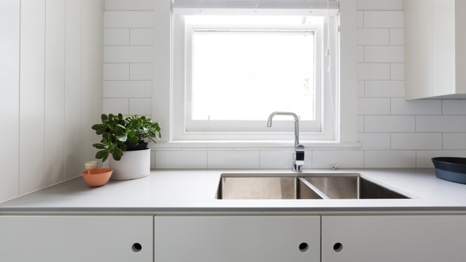 A contemporary white kitchen with laminate countertop