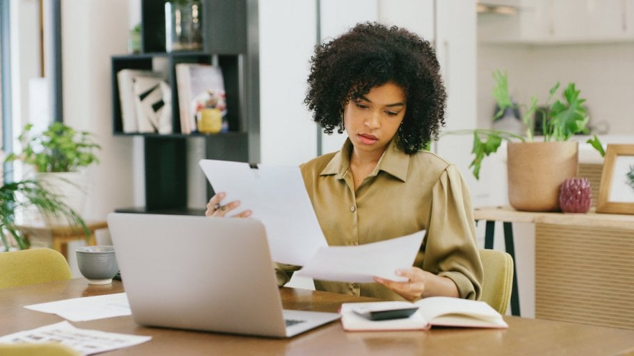 A contractor checking her papers while doing a cost estimate