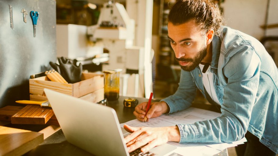 A contractor using a laptop at his office