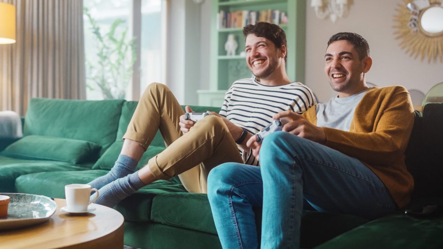 A young couple playing video games in the living room (Photo by Gorodenkoff - stock.adobe.com)