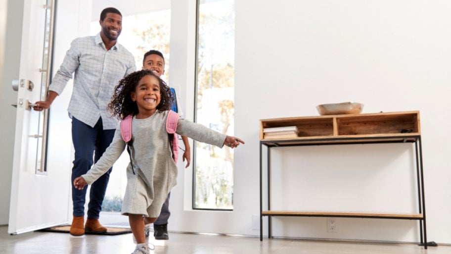 father, daughter and son arriving home through front door
