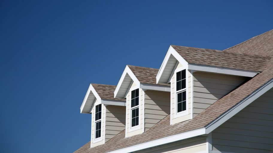 three dormer windows with blue sky in background