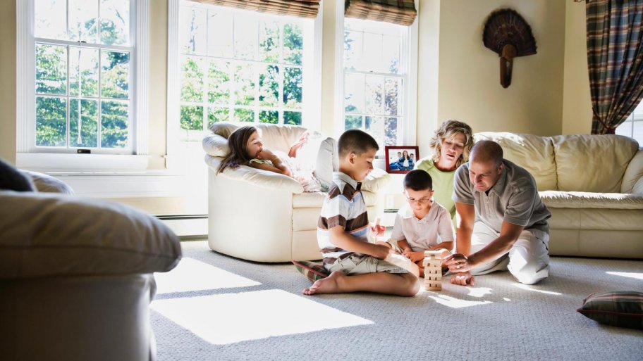 Family laying on the carpet and playing a game