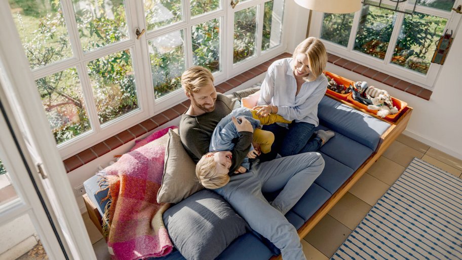 family playing on couch in sunroom