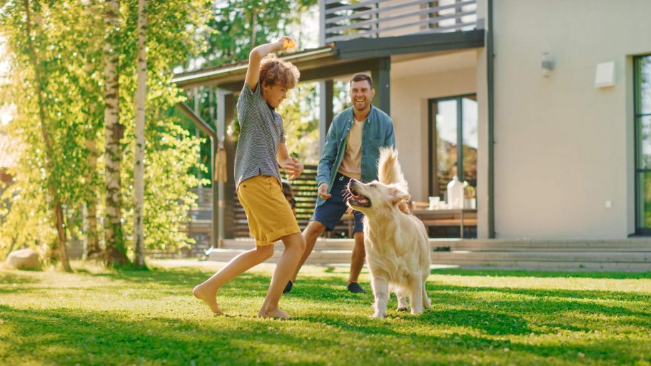 A father with his son and their dog playing in the backyard (Photo by Gorodenkoff - stock.adobe.com)