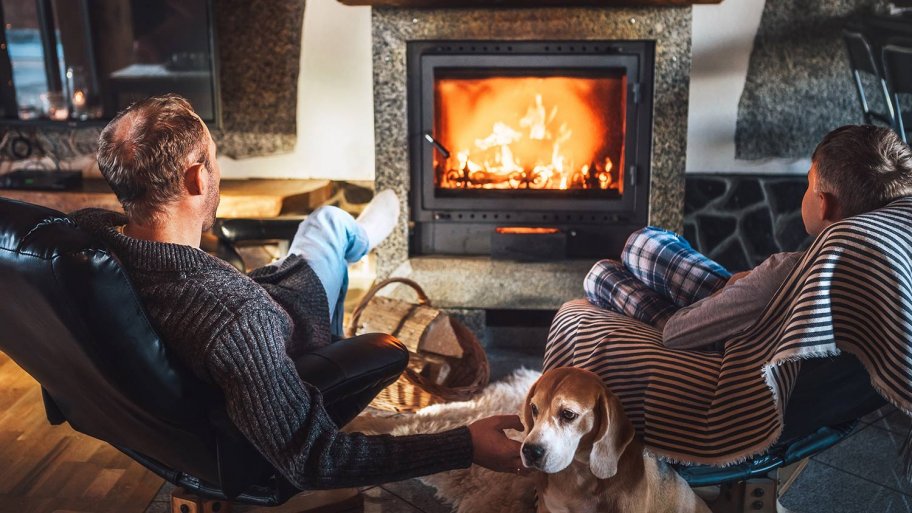 Father and son sit near fireplace