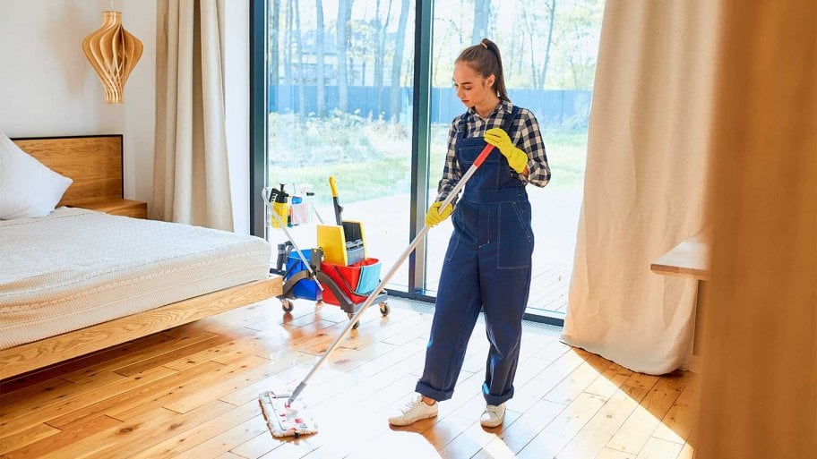Female cleaner mopping bedroom floor