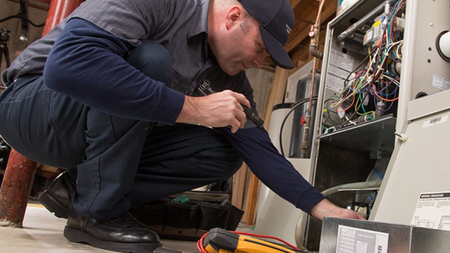 HVAC technician inspecting A/C unit