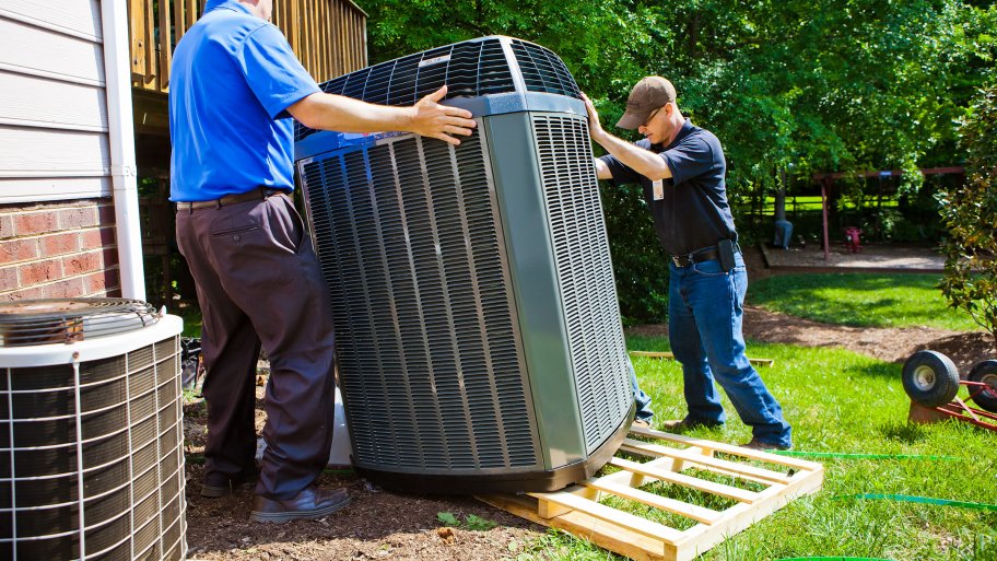 two men installing an HVAC unit