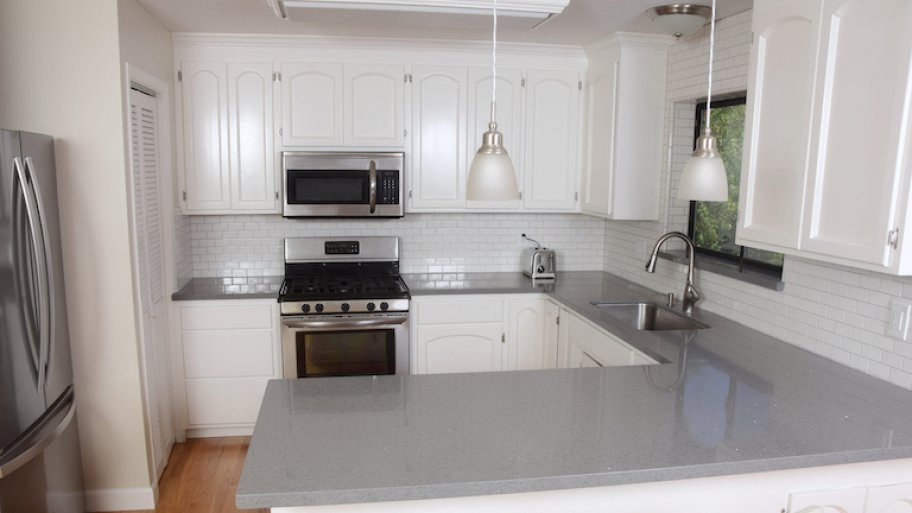 kitchen with white cabinets, gray countertop, and silver fixtures