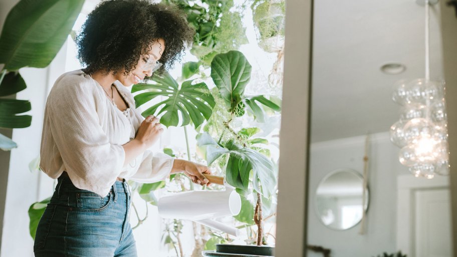 Young Woman Waters Her Houseplants