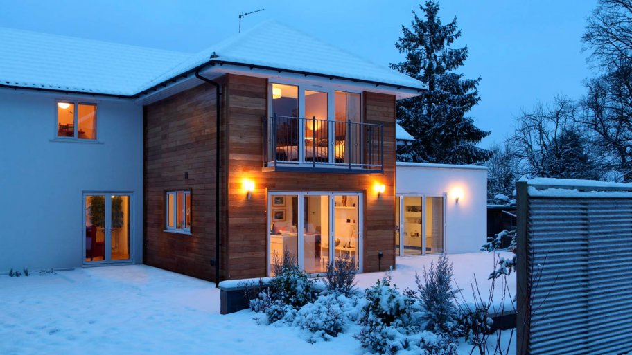An illuminated house at dusk in snow