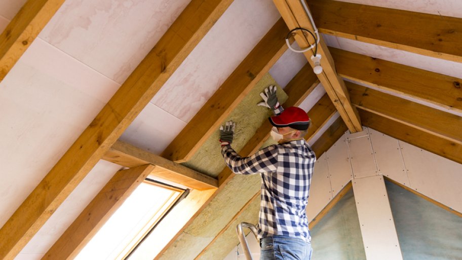 Contractor installing insulation in ceiling