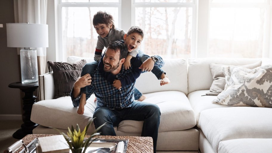 Two kids having fun with their father in their living room (Photo by gradyreese/E+ via Getty Images)