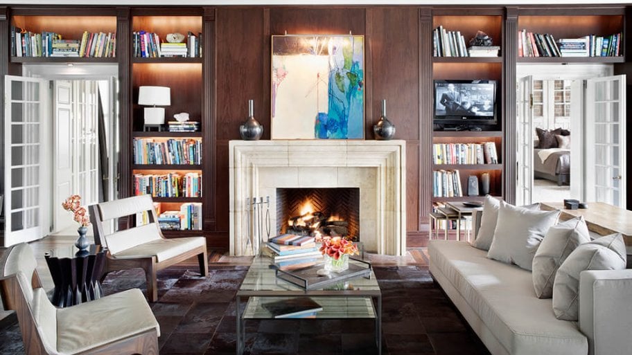 Library sitting room with built-in bookcases and a white fireplace Library sitting room with built-in bookcases and a white fireplace
