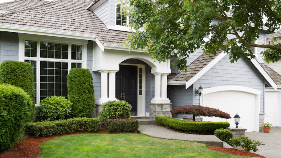 home exterior featuring light blue painted siding and green landscaping