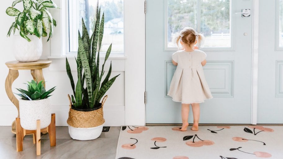 A little girl looking out of the door in a modern, bright house