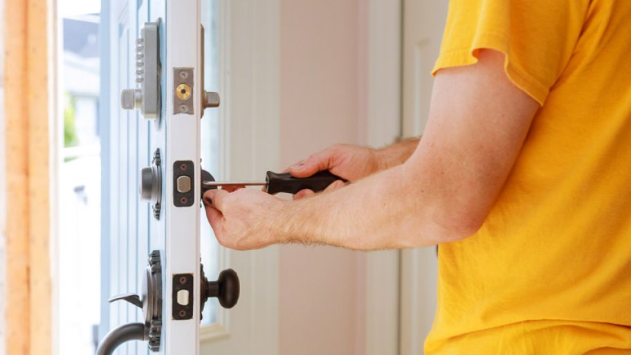 A locksmith changes a door’s lock
