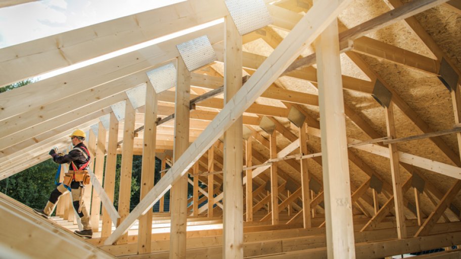 Man builds the wooden roof of a barn Man builds the wooden roof of a barn