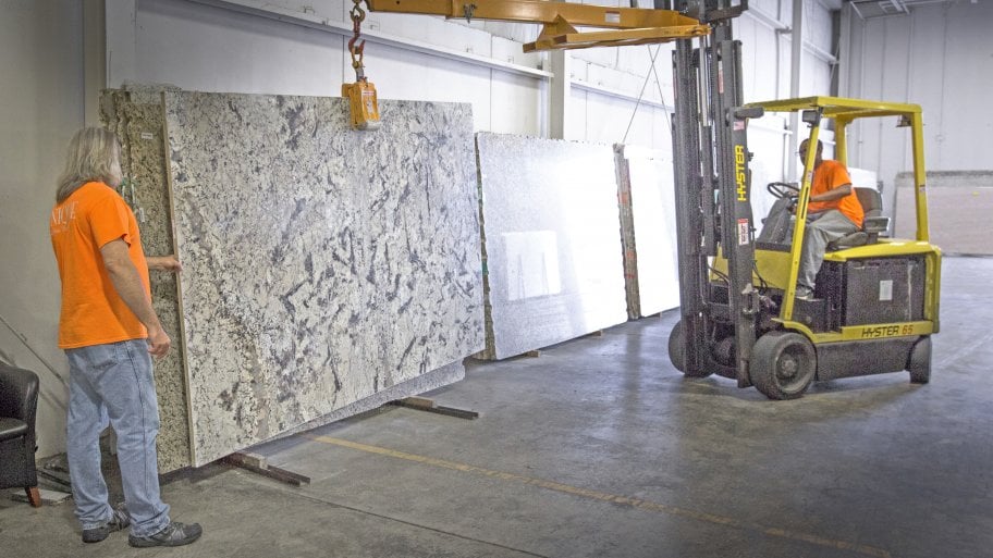 marble slab being hoisted by heavy equipment