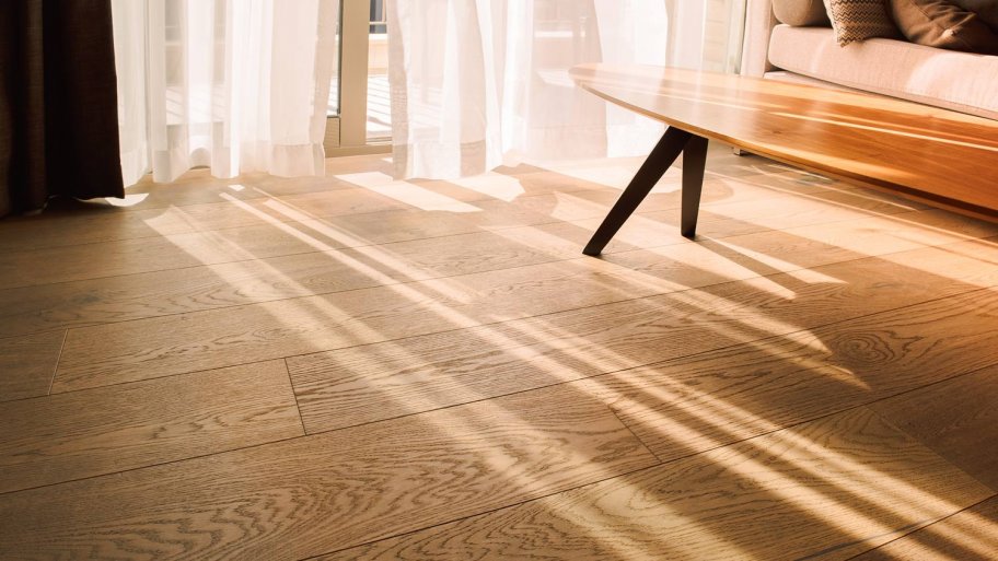 A sunlit modern living room with laminate flooring