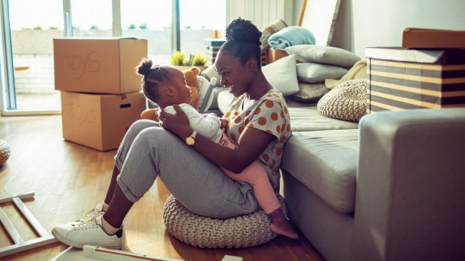 Mother playing with child while packing Mother playing with child while packing