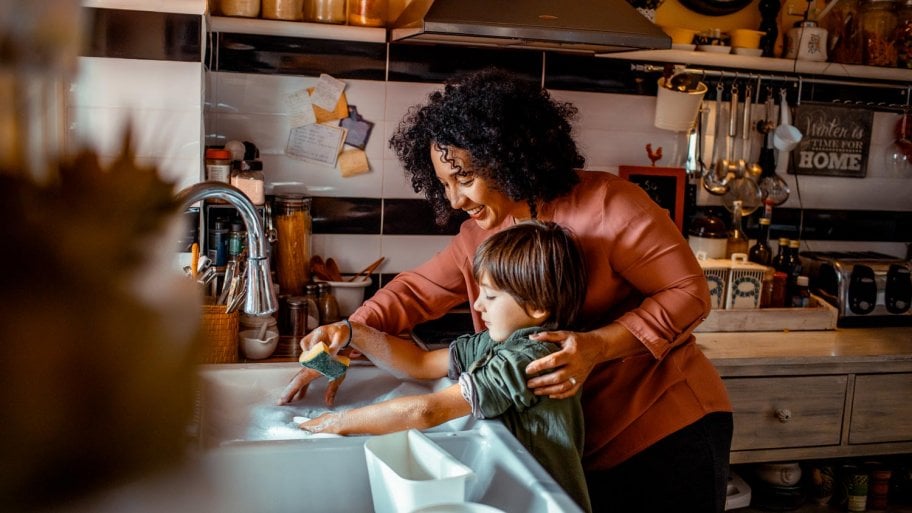A mother with her son doing the dishes