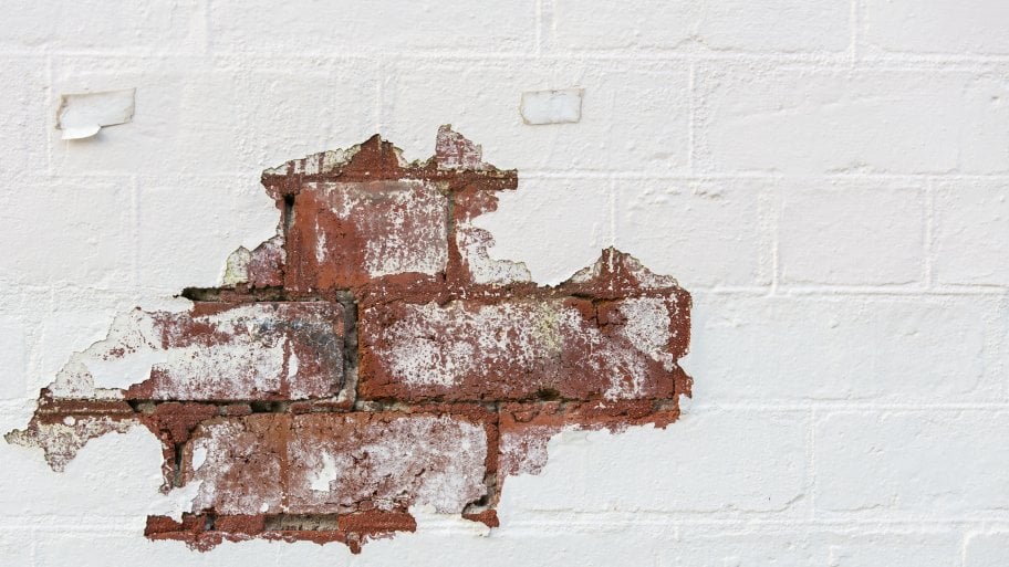 chipped white Limewash paint exposing brick