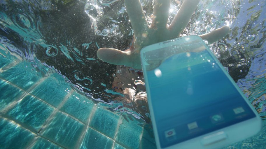 Hand reaching for phone dropped in pool
